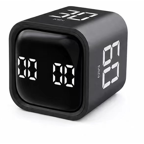 A black cube-shaped digital alarm clock with white LED seven-segment displays showing '00' on the front and '6:01' on the side, photographed on a clean white background.